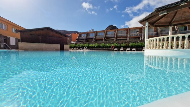 A clear swimming pool with lounge chairs and a building with balconies in the background. - Cozy apartment with Jacuzzi/ fast WIFI/PS5/huge pool and kids pool. Family place (CN)