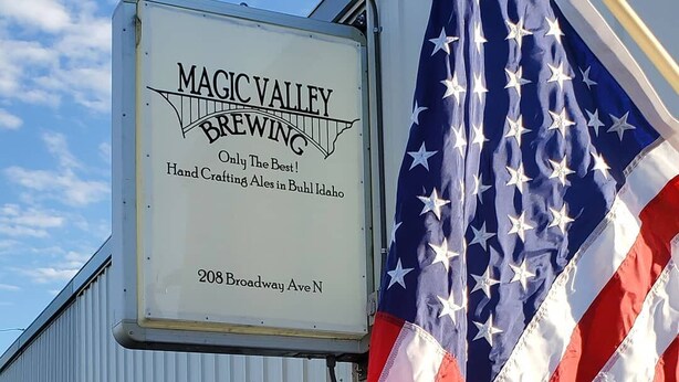 A building with a sign for Maci Valley Brewing, featuring an American flag.