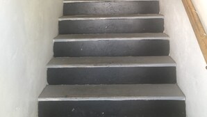 Un escalier avec une rampe en bois et un mur blanc.