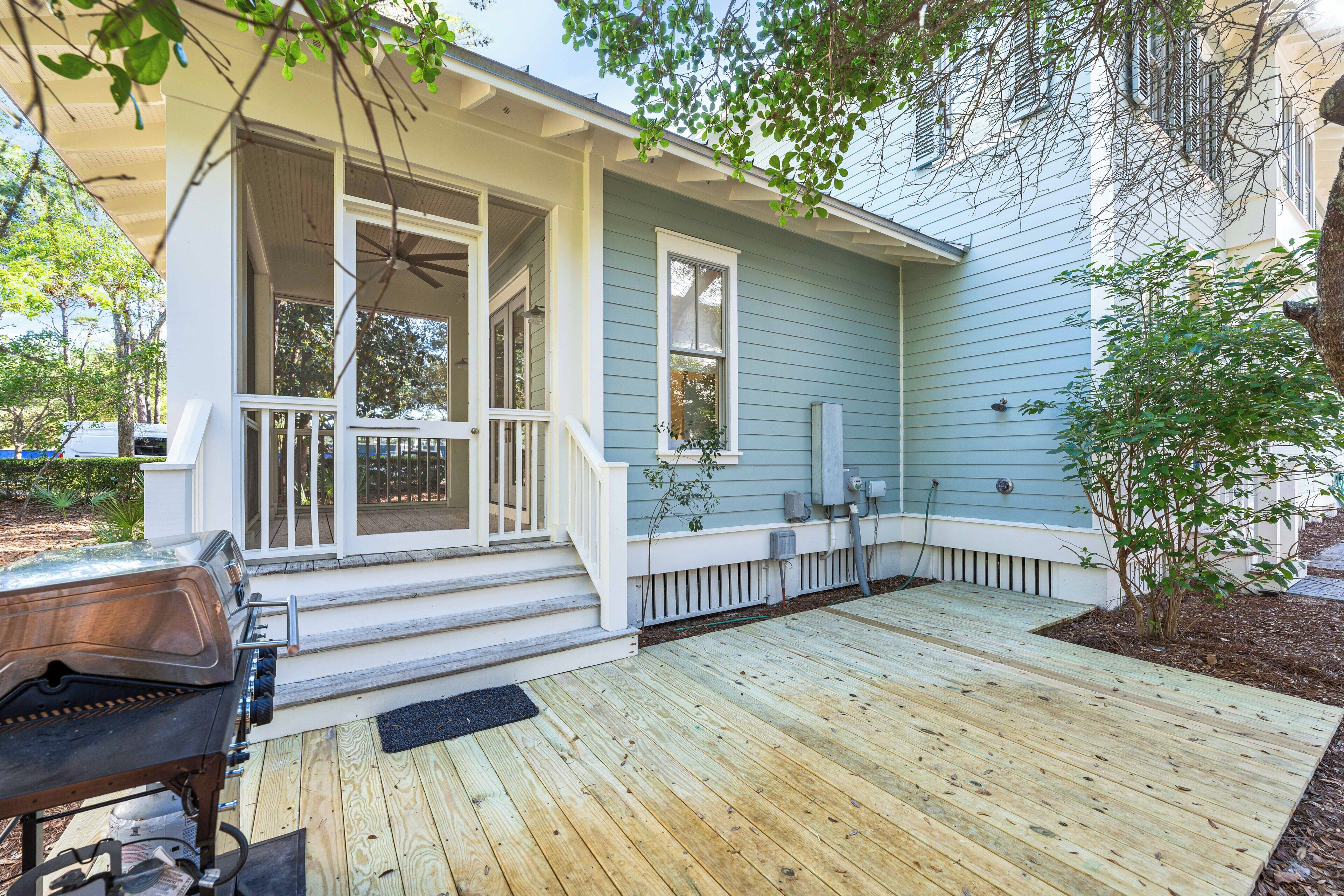 A house with a porch, a grill, and a small garden.