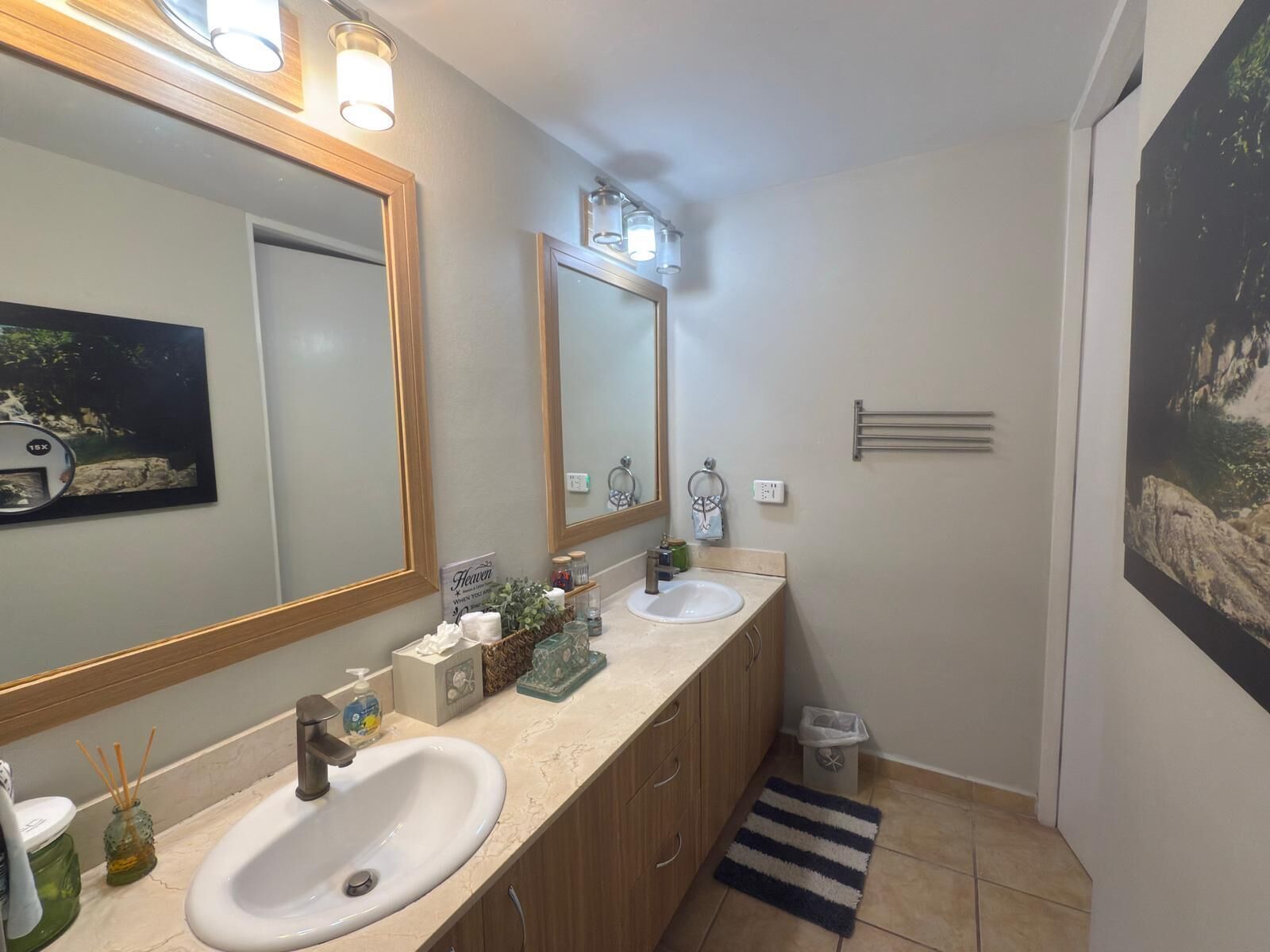 Ein Badezimmer mit zwei Waschbecken, einem großen Spiegel und einem Handtuchhalter.