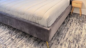 Un dormitorio con una cama grande, una mesita de noche y un ventilador de techo.
