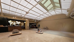 A spacious indoor area with a high ceiling and skylights, featuring a reception desk, seating areas, and a bicycle rack. - Tu Refugio en el Corazón de Montserrat (Buenos Aires)
