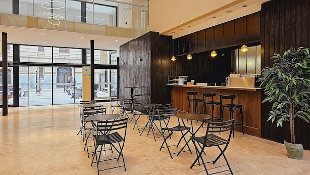 A spacious indoor area with a high ceiling, a bar area with stools, and a large potted plant. - Tu Refugio en el Corazón de Montserrat (Buenos Aires)