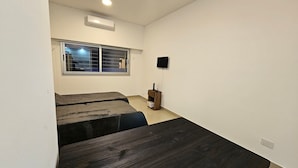 A room with a large window, a flat-screen TV mounted on the wall, and a wooden cabinet. - Tu Refugio en el Corazón de Montserrat (Buenos Aires)
