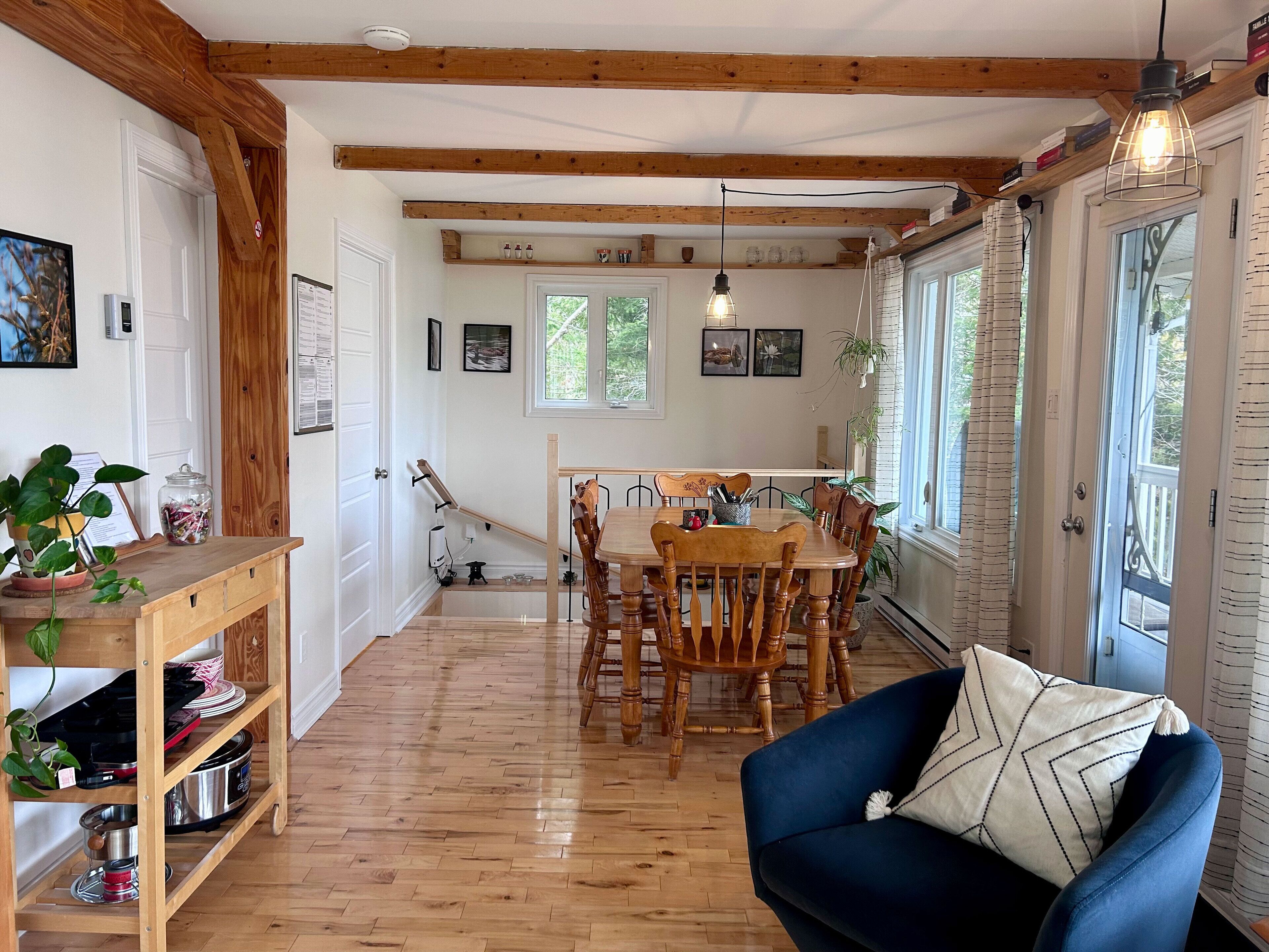 Un coin repas accueillant, avec des meubles en bois, un canapé bleu et une table à manger entourée de chaises.