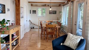 Un comedor acogedor con mobiliario de madera, un sofá azul y una mesa de comedor con sillas.