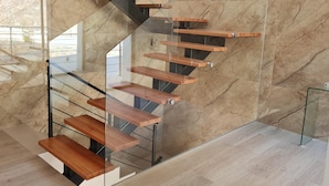 Eine moderne Treppe mit Glastrennwand und Holzbeschlägen.