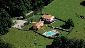 An aerial view of a property with a large house, a swimming pool, and surrounding greenery. - Two Bedroom Apartment (GAMBASSI TERME)