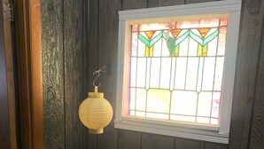 A room with wooden paneling, a stained glass window, and a hanging lantern. - Welcome to the Gathering Place! Where Families and friends can gather together.  (McKeesport)