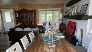 A dining area with a wooden table, chairs, and a candelabra centerpiece. - Sunrise net on Pigeon Lake 4 season cottage (Kawartha Lakes)