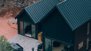 Ein modernes Haus mit einer großen Terrasse, einem Kamin und einem Schornstein.