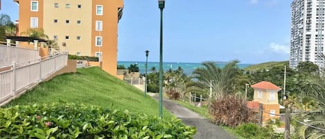 A pathway leading to a building with a view of the ocean.