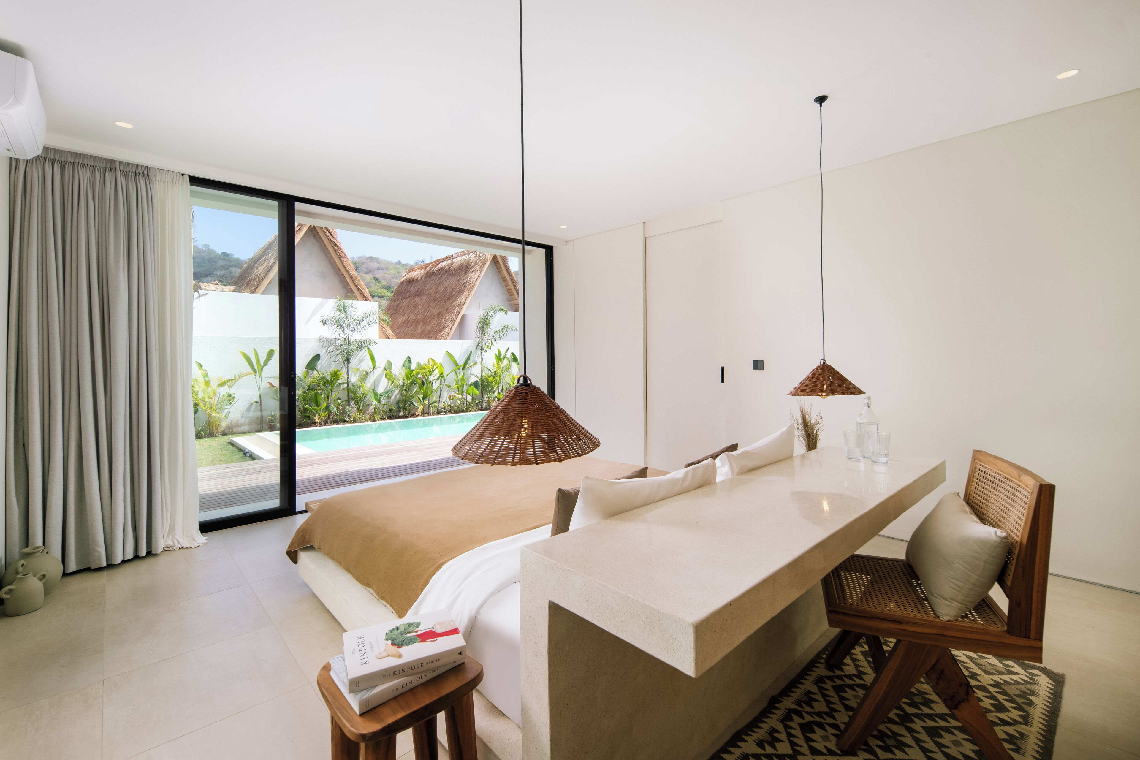 Une chambre moderne avec un grand lit, une table à manger et une vue sur une piscine et un jardin.