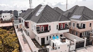 Un immeuble résidentiel doté de nombreux balcons, d’un toit plat et de panneaux solaires.