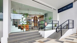 A modern building entrance with glass doors, a staircase, and a railing. - Ink Hotel by ALV (George Town)