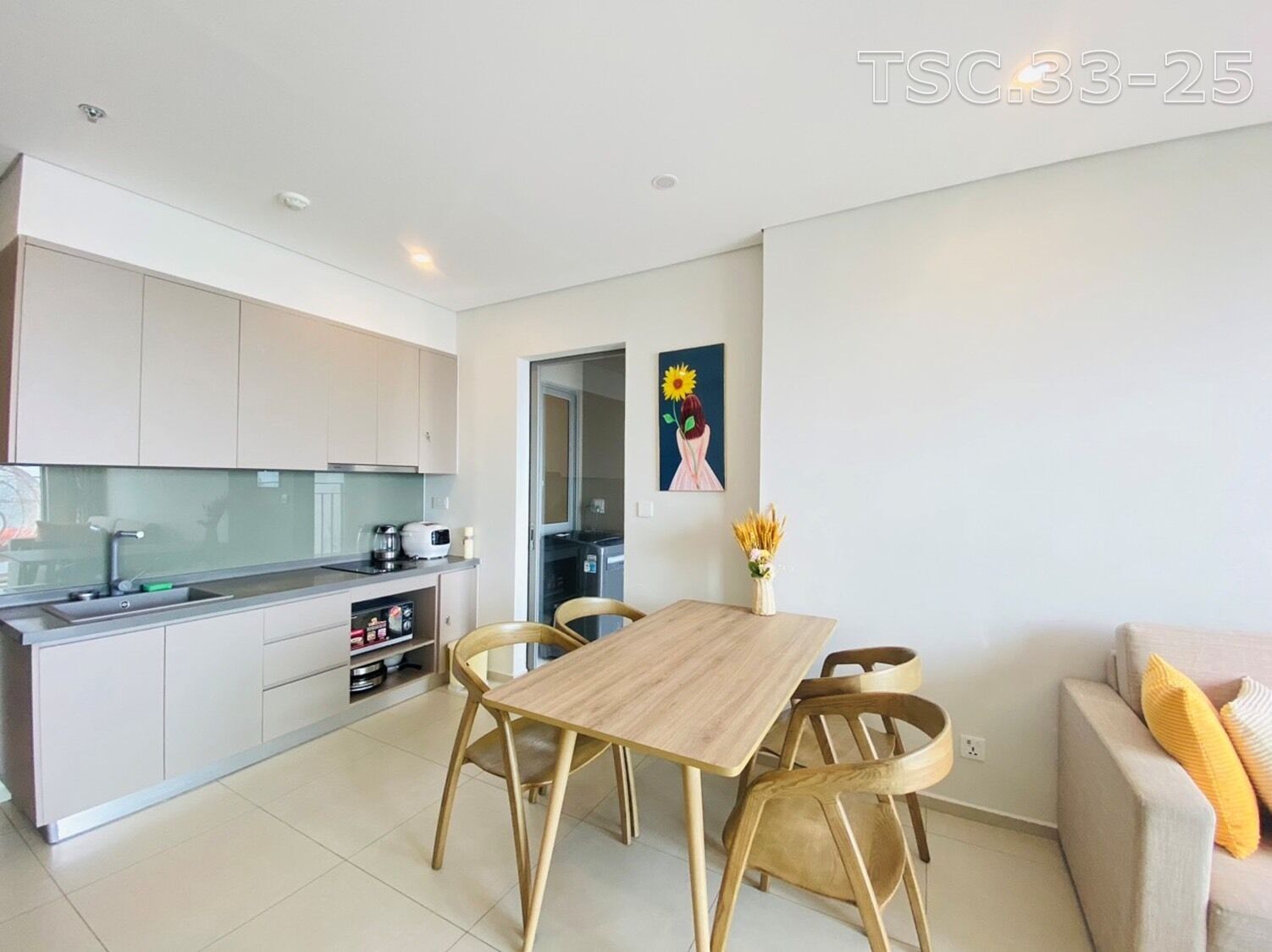 Una cocina moderna con armarios blancos, una mesa de comedor de madera y dos sillas.