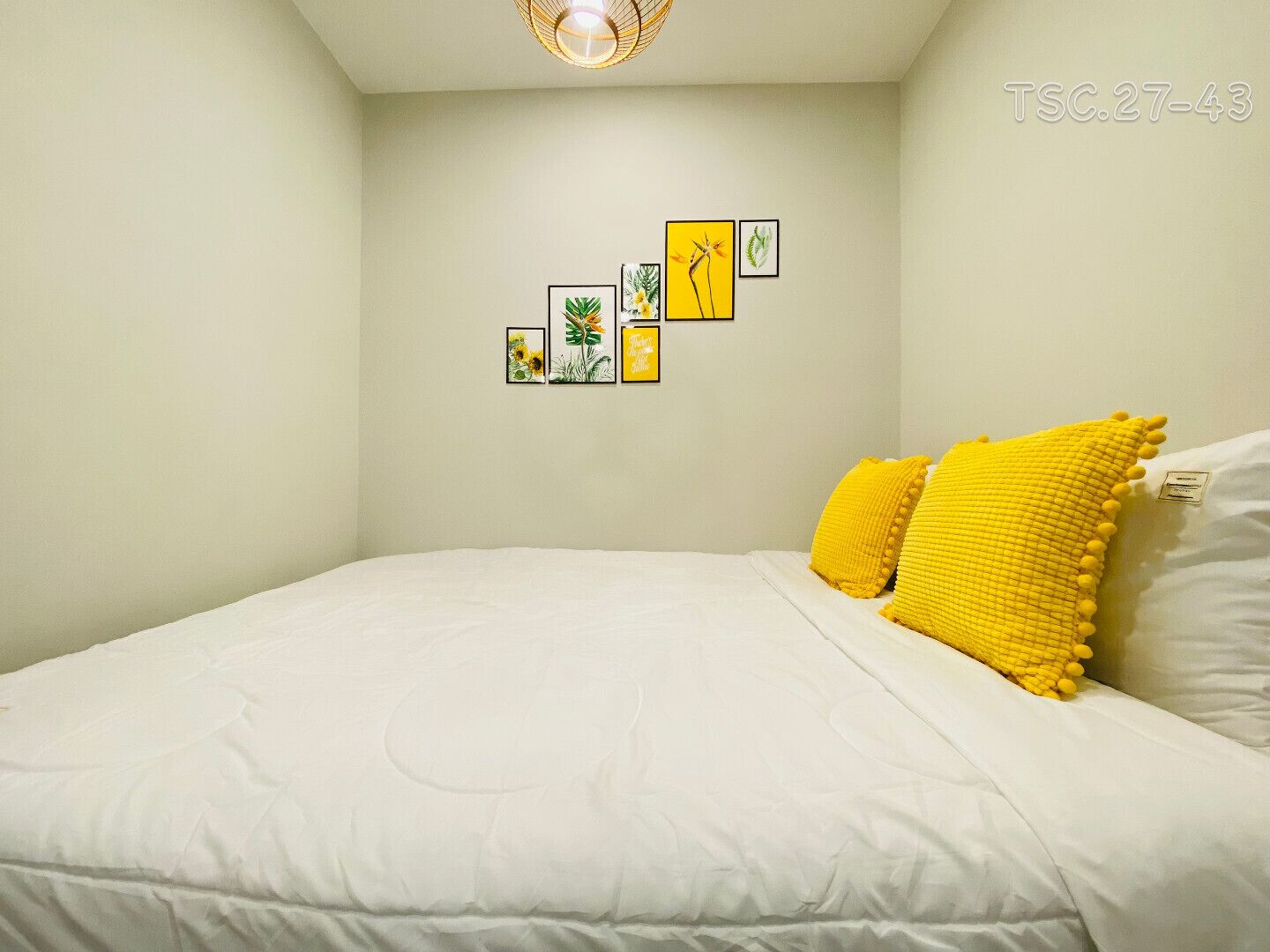 A bedroom with a bed, white bedding, and a yellow pillow.