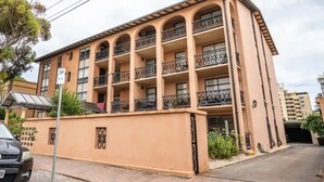 A multi-story building with balconies, a covered parking area, and a visible entrance. - Sunsets at Glenelg - entire 3 bedroom apartment
 (Glenelg)
