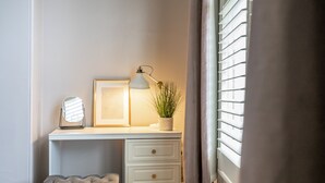A white desk with drawers, a framed picture, a lamp, and a potted plant. - Aycliffe Cottage  -  a family break that sleeps 6 guests  in 3 bedrooms (York)