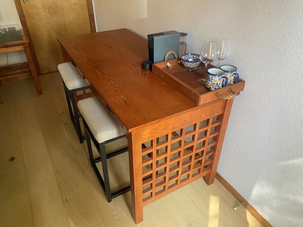 Une table de salle à manger en bois, accompagnée d’un banc, d’un petit meuble et d’objets décoratifs.