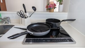 A kitchen with a stove, two frying pans, a spatula, and a set of kitchen utensils. - H2H Tsutenkaku (Osaka)