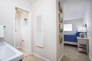 A bedroom with a bed, a nightstand, a window, and a door leading to a bathroom. - Relax in Peace | Dog Friendly | 1 mile to Beach (Nokomis)