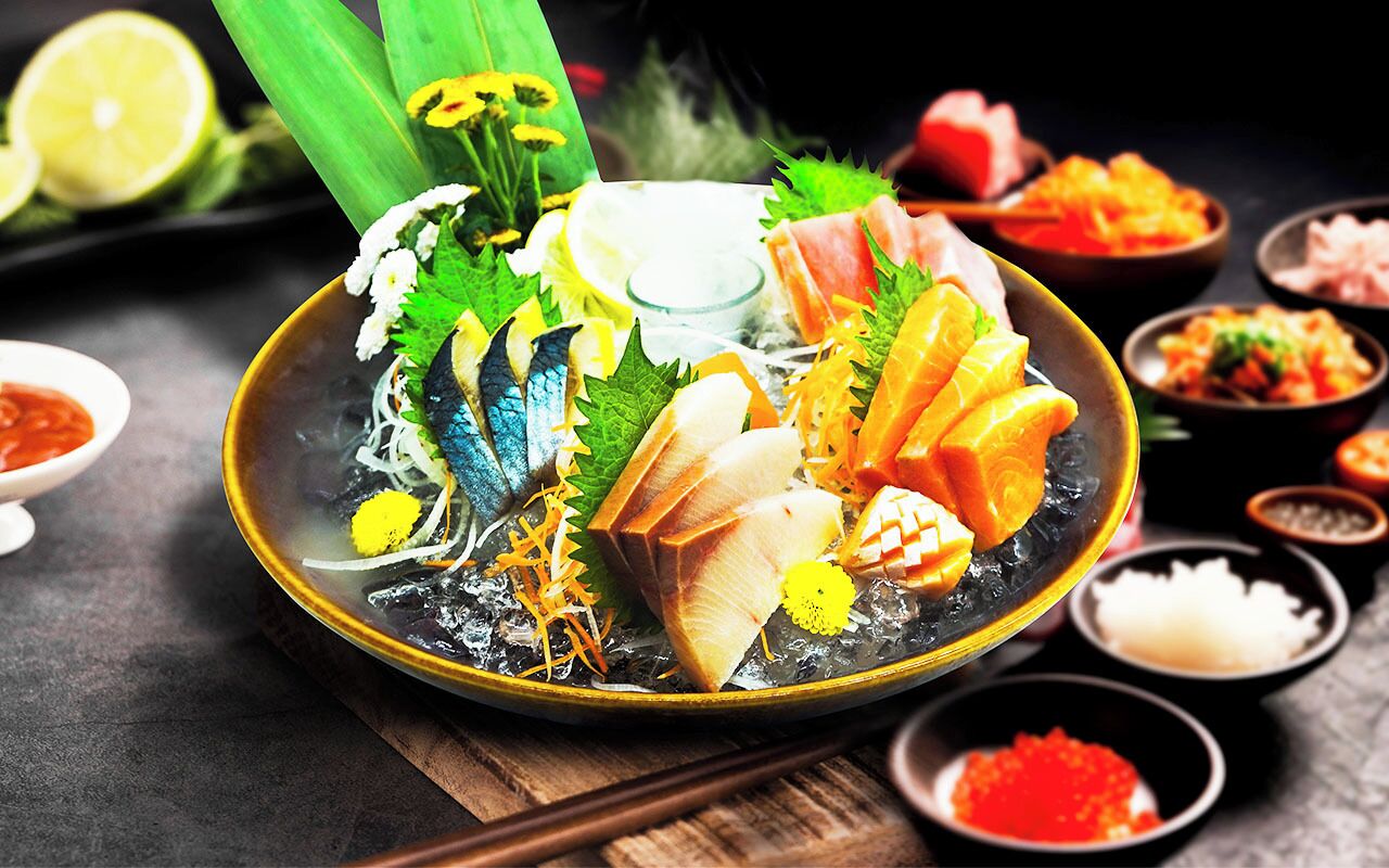Un bol de sashimi, composé de différents types de poisson et agrémenté de diverses garnitures.