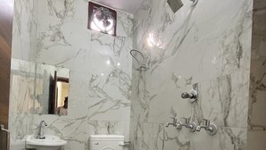 Une salle de bain avec des toilettes, un lavabo et une douche.