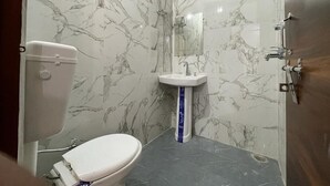 Une salle de bain avec des toilettes, un lavabo et un miroir.