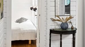 A bedroom with a bed, a bedside table with a vase, and a mirror on the wall. - "Neela" - 300m from the sea by Interhome (Væggerløse)