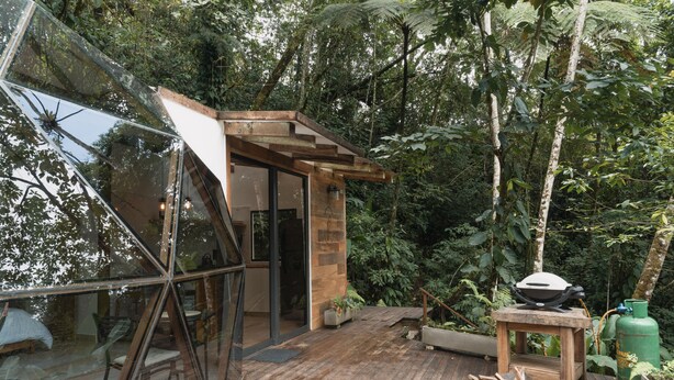 A wooden deck with a glass enclosure, surrounded by lush greenery. - TERRAMIA ESTATE (Santa Marta)