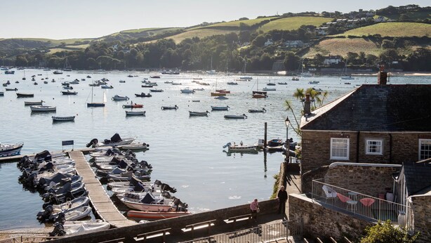 A harbor with numerous boats docked and a stone building with a balcony overlooking the water. - High Tide -  a house that sleeps 6 guests  in 3 bedrooms (Salcombe)