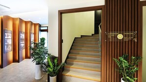 Ein Empfangsschalter mit Hinweisschildern zum Lounge-Bar, zum Partyraum, zum Schwimmbad und zur Sauna.