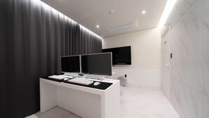 Ein modernes Badezimmer mit einem großen Waschtisch, einem Fernseher mit zwei Bildschirmen und einer Toilette.