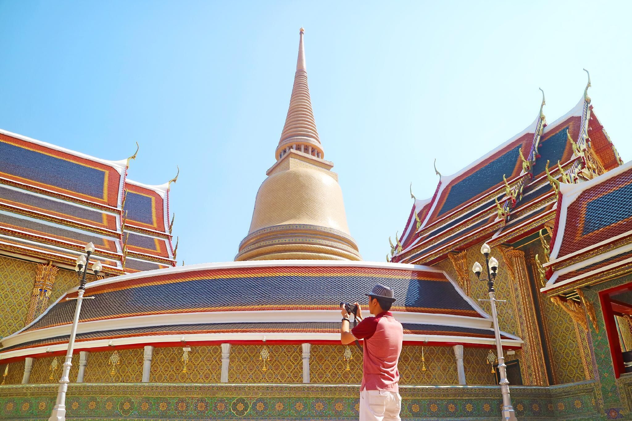 Un templo grande con una aguja alta, decoraciones ornamentales y una persona tomando una fotografía.