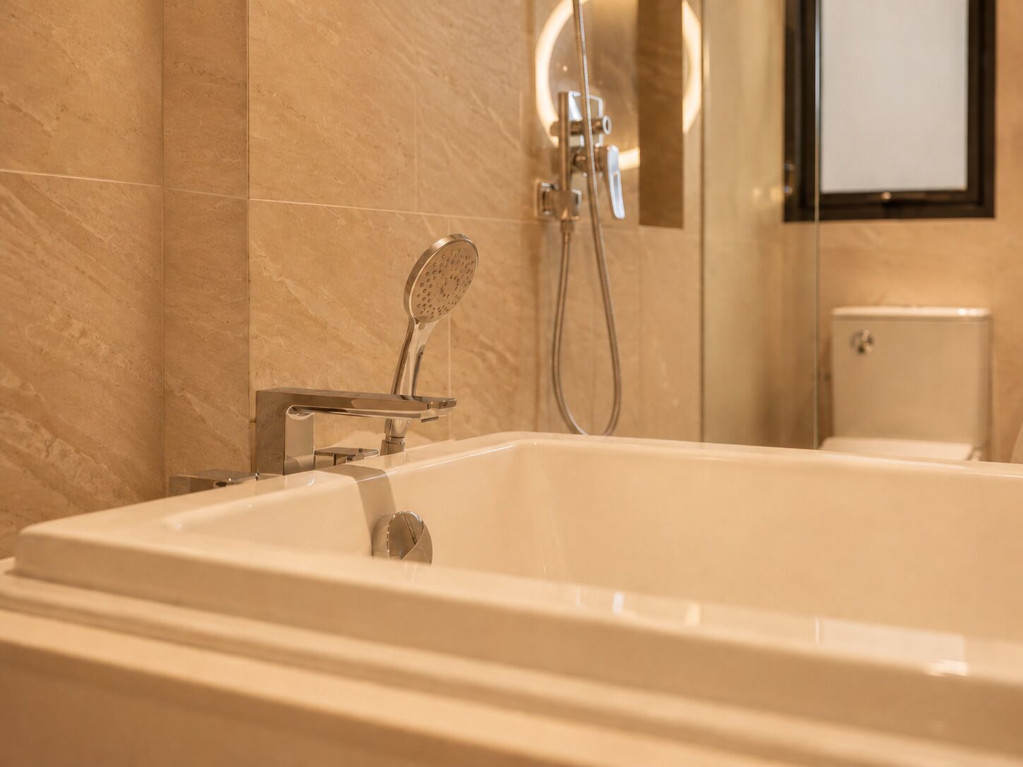 A modern bathroom with a freestanding bathtub, a handheld showerhead, and a wall-mounted faucet.