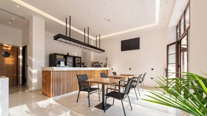 A modern kitchen with a central island, a dining area with a table and chairs, and a large window providing natural light. - The Wine Hotel (Rhodes)