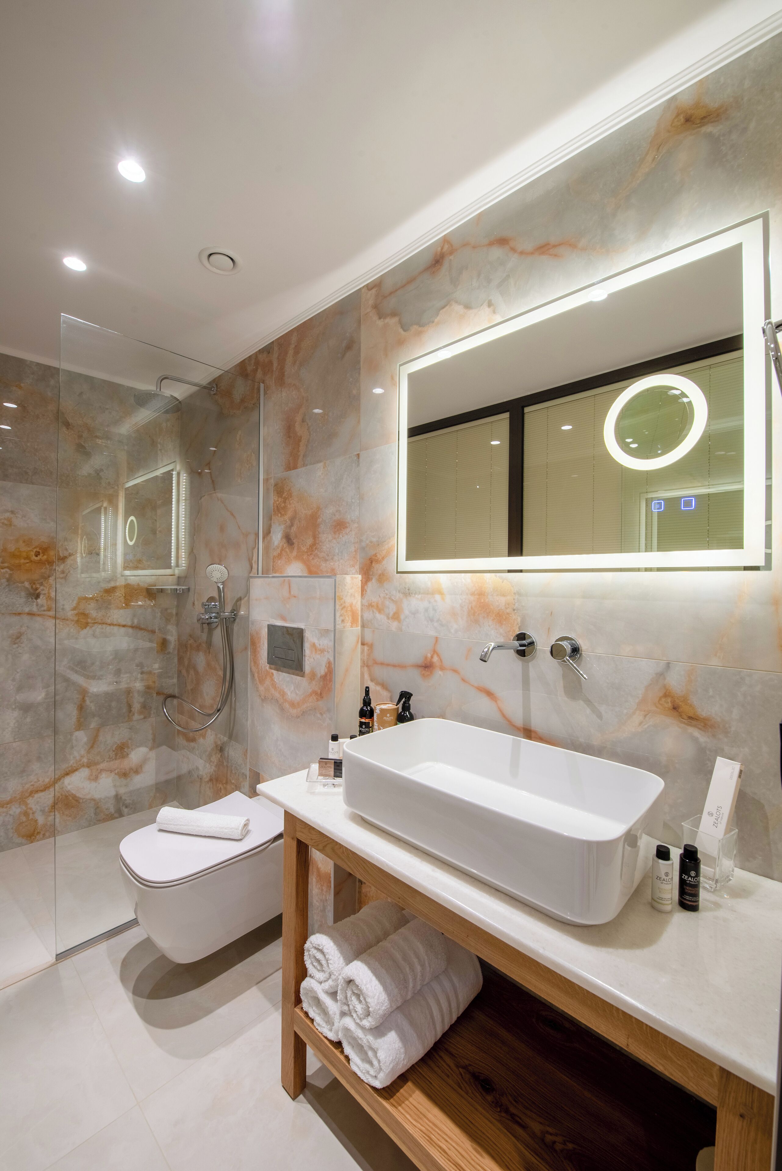 Une salle de bain moderne avec une baignoire sur pieds, une douche à parois de verre et un pare-baignoire en marbre.