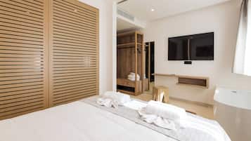 Una camera d'albergo moderna con un letto grande, un armadio in legno, una TV e un piccolo sgabello di legno.