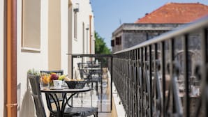 A balcony with a table set for breakfast, including fruits, bread, and a cup. - The Wine Hotel (Rhodes)