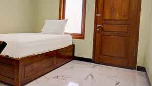 Un dormitorio con una cama y una puerta de madera, y un ventanal.