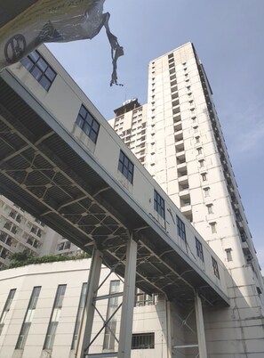 A high-rise building with a modern architectural design, featuring a prominent overpass structure in the foreground. - OYO Life 92745 The Margo Monthly Stay (Depok)