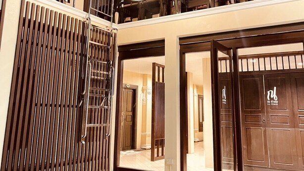 A multi-level interior with a staircase, wooden railings, and a hanging light fixture. - Na Thapae Chiangmai Hotel (Chiang Mai)