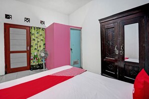 Un dormitorio con cama, ventilador, armario y puerta con cortina.