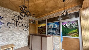 Un espace d’accueil doté d’un plafond en bois, d’un comptoir de réception et d’œuvres d’art accrochées aux murs.