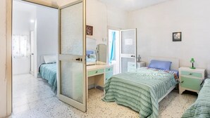 Un dormitorio con cama, escritorio, armario y mesita de noche.