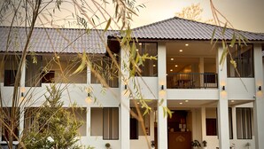 A two-story building with a balcony on the upper floor, a covered entrance, and a driveway leading to the entrance. - น่าน ม่วนใจ Nan Muanjai Hotel (Pua)