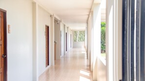A long, narrow hallway with doors on both sides, leading to rooms. - น่าน ม่วนใจ Nan Muanjai Hotel (Pua)