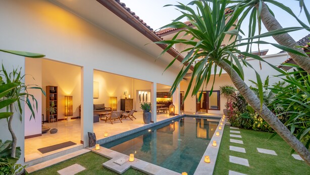 Une maison moderne dotée d’une piscine, d’un espace extérieur aménagé et d’intérieurs bien éclairés.